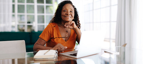 Black senior woman working and managing her business from home