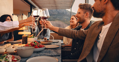 Friends enjoying dinner and drinks on an evening terrace