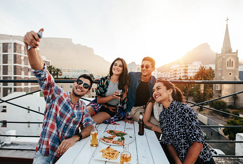 Young people taking selfie on rooftop party 