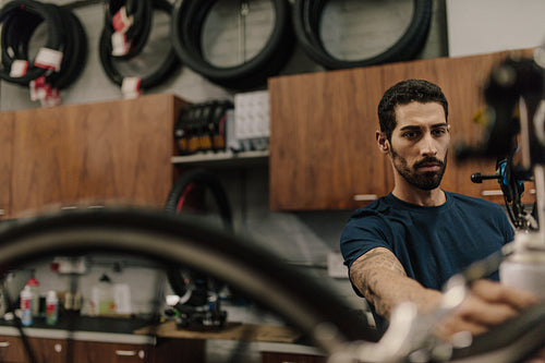 Mechanic assembling a bicycle in workshop