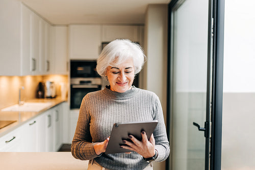Smiling senior woman using a digital tablet at home