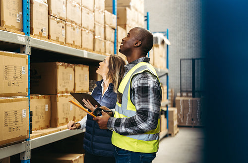 Logistics workers looking up a a storage shelf in a warehouse