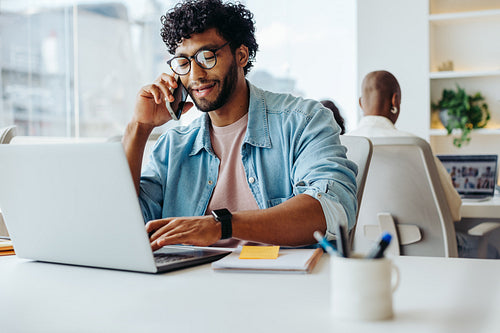 Successful entrepreneur working at modern office desk with laptop and smartphone