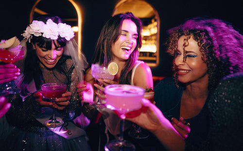 Group of friends celebrating with drinks and laughter at a vibrant party