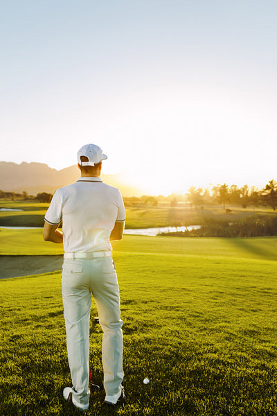 Male golfer standing at tee square on course.