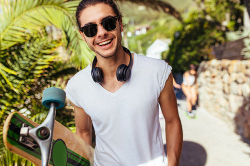 Handsome young man on vacation with longboard 