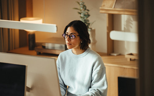 Working woman uses a computer for programming at her desk