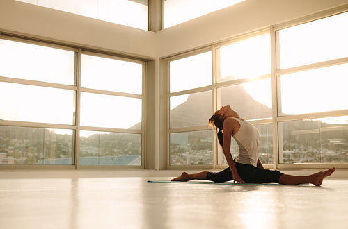 Woman doing a split on yoga mat