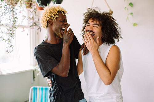 Two male lovers laughing together at home