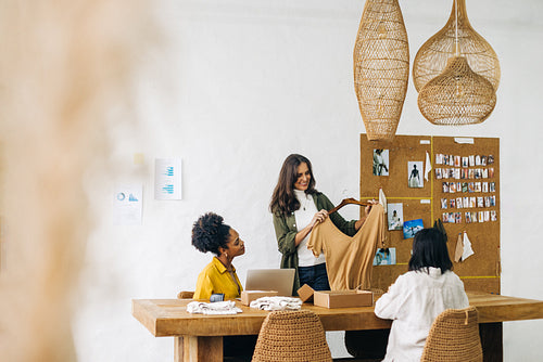 Group of women packaging clothing items for drop shipping in their online fashion store