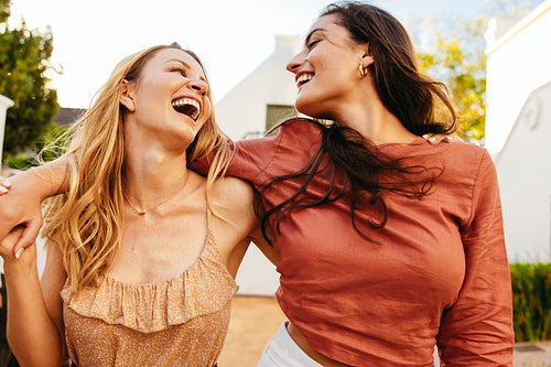Friends laughing while embracing each other