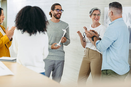 Successful designers applauding cheerfully during a meeting