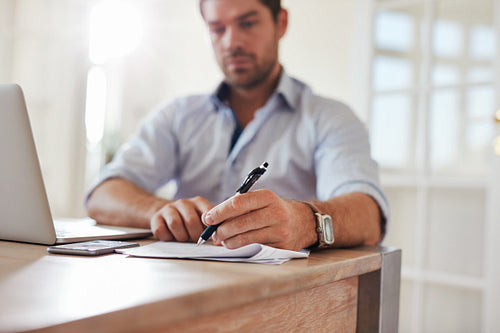 Young businessman at home office signing documents