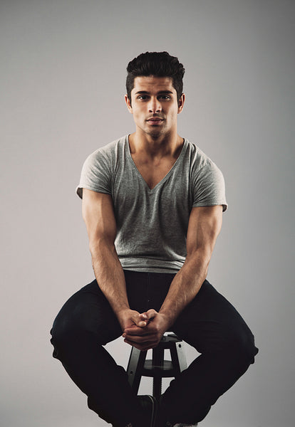 Muscular young male model sitting on stool