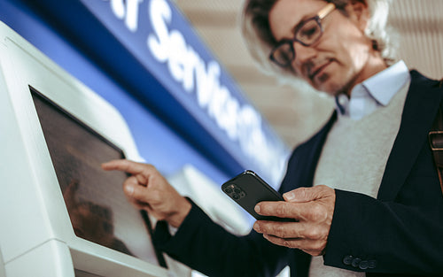 Business traveler making self check for flight at airport