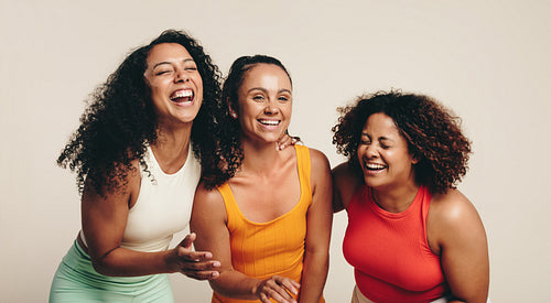 Sports, fitness and friendship: Group of young women laughing happily, dressed in sportswear