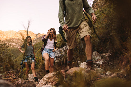 Group of friends walking through a mountain trail