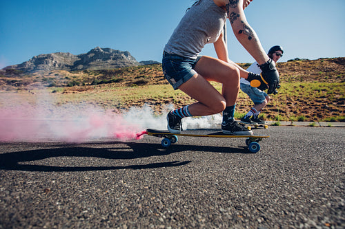 Man and woman longboarding down the road