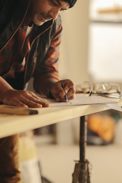 Home redesign: Man working on a home renovation plan with blueprints