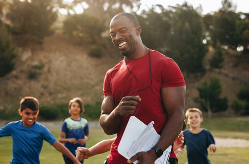 Coach having a fun training session with kids in a school