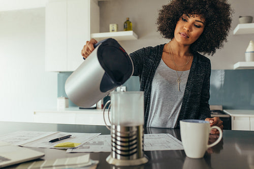 Woman making coffee at home office