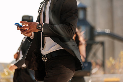 Man using mobile phone while walking on street