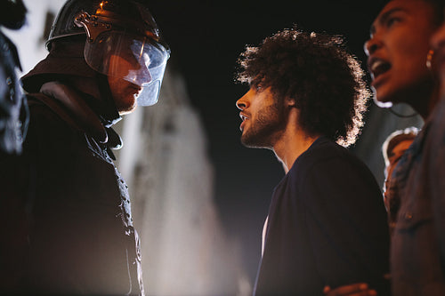 Angry protestors protesting in front of policemen