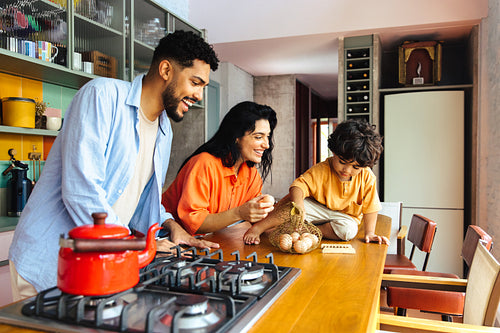 Parents and child spending quality family time in a bright modern kitchen