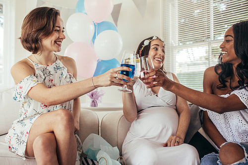 Multiracial friends at baby shower party having juices