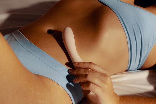 Young woman exploring her sexual passion with vibrating adult toys