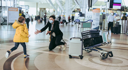 Boy meeting mother arriving at airport