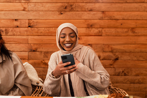 Happy muslim having a video call in a restaurant