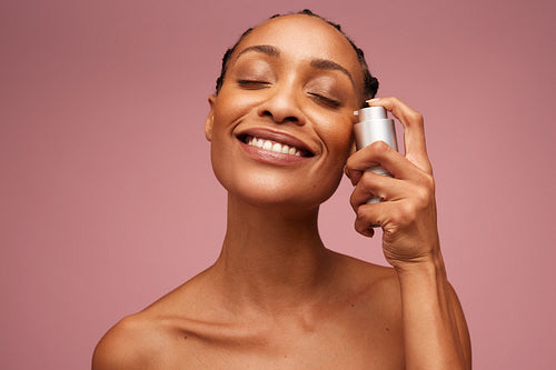 Beautiful woman applying serum to her face