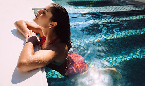 Young woman enjoying the sun while in a swimming pool