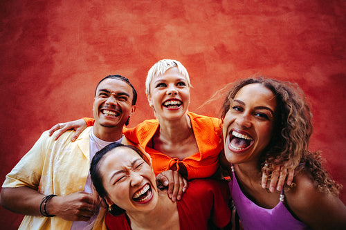Friends laugh together in a bold urban group portrait outdoors