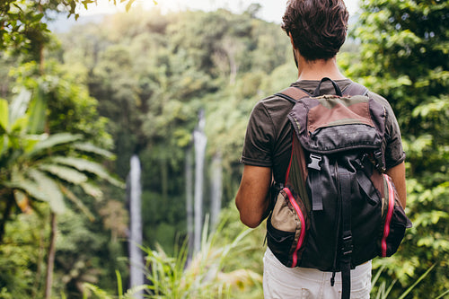 Young male hiker admiring the waterfall
