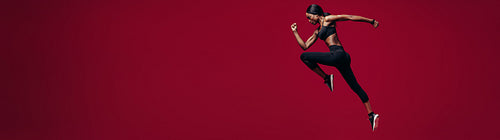 Fitness woman running over red background