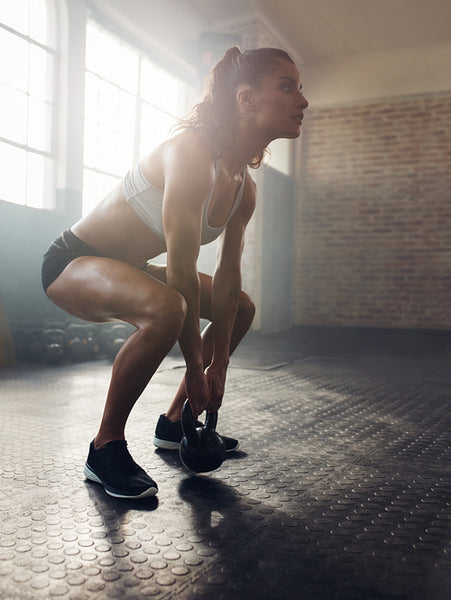 Fitness woman working out with kettle bell
