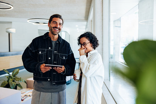 Two colleagues share a laugh in office lounge