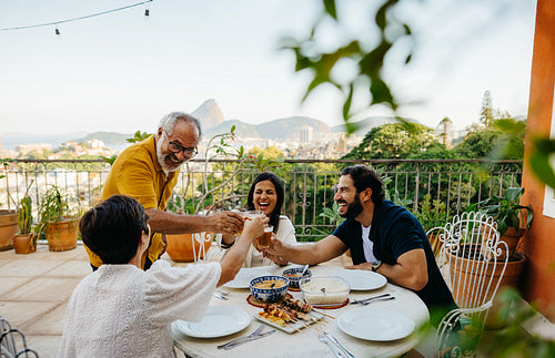 Family enjoying a barbecue on a terrace with a scenic city view