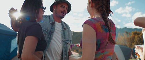 Excited young friends greeting and hugging at a festival
