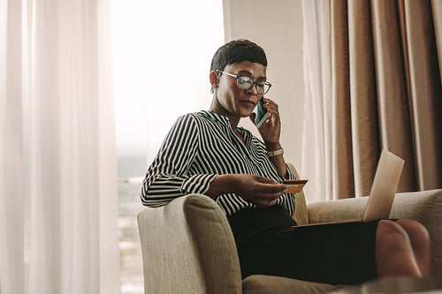 Businesswoman doing online payments from hotel room