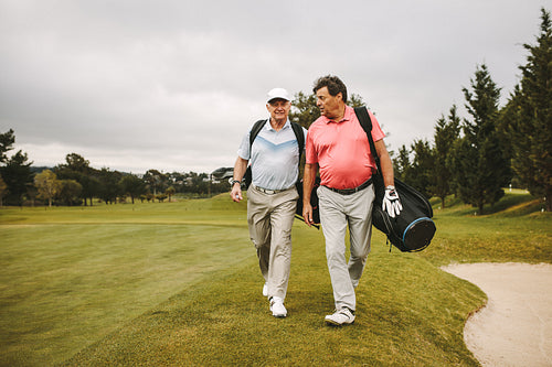 Senior golf players walking together on the golf course