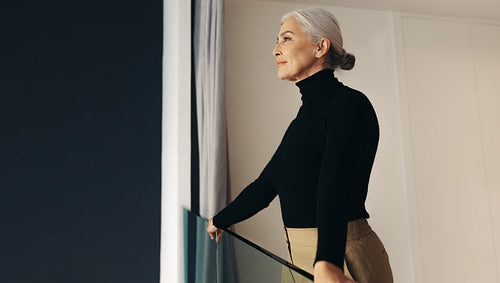 Successful businesswoman taking a moment to reflect while standing on office balcony