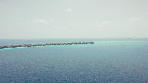 Seaplane arriving at a luxury overwater bungalow resort in the clear turquoise Maldives