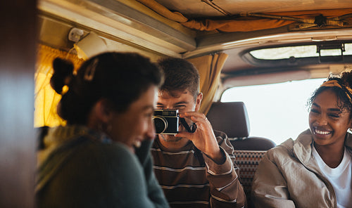 Friends inside a van taking photos and sharing laughter