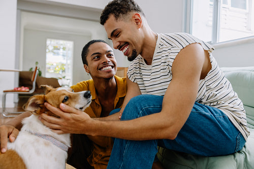 Happy couple bonding with their dog in a cozy living room setting