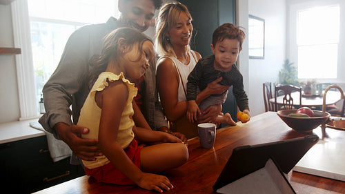 Family time with technology: Parents and kids video chat with their extended family on a tablet