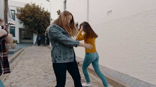 Girl friends dancing outdoors on the street