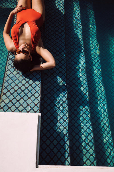 Female tourist tanning by the pool